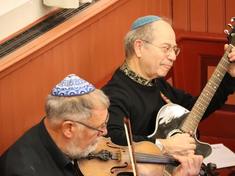 Twee muzikanten met keppel spelen viool en gitaar