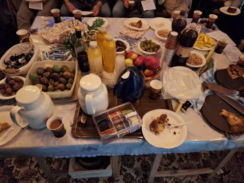 Tafel vol lekkernijen in de Soeka: dadels, olijven, granaatappels, gebak, sap en koffie